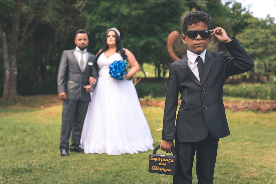Ring bearer carrying a Here Comes the Bride wooden sign down the aisle