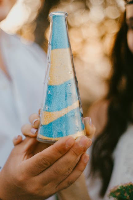 Layered colored sand in a glass unity ceremony vase as a wedding keepsake
