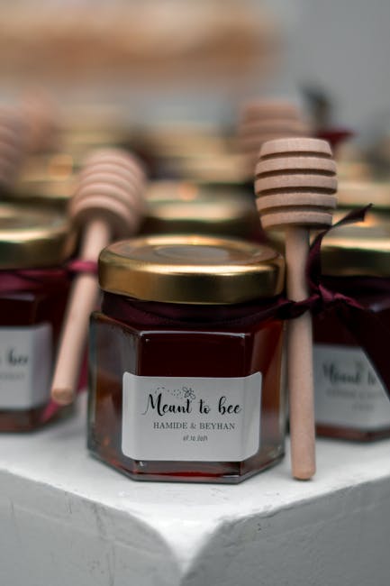Mini honey jar wedding favors with wooden dippers — an edible favor guests will actually use