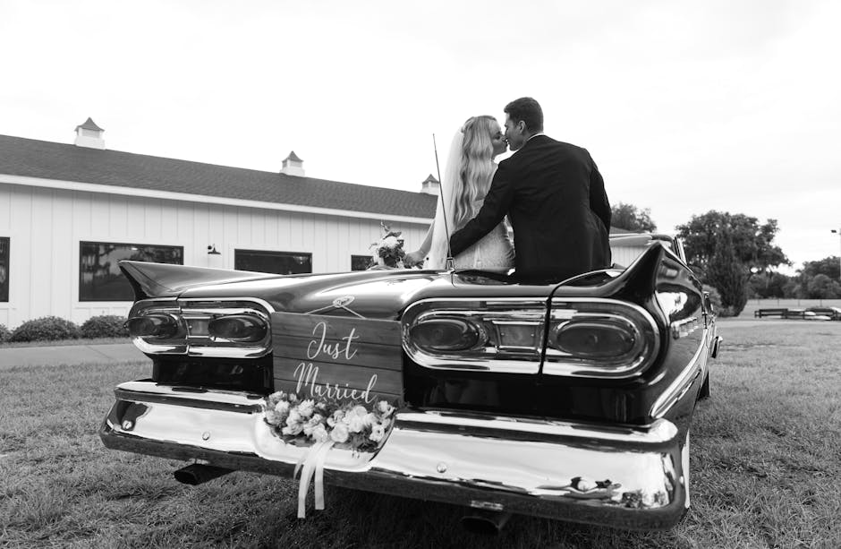 Wedding car with Just Married hand-lettered in white chalk marker on the rear window