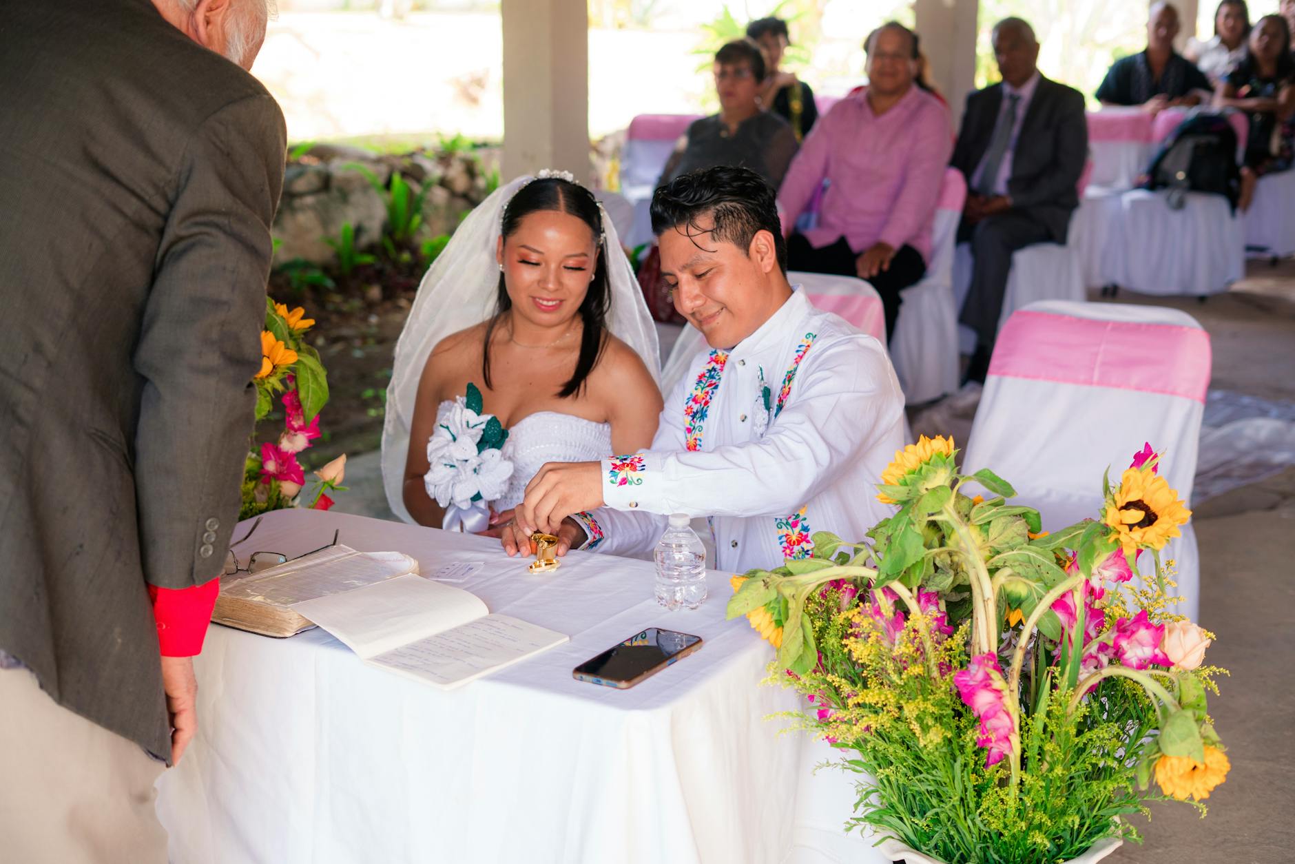 Wedding vow books displayed on sweetheart table with florals