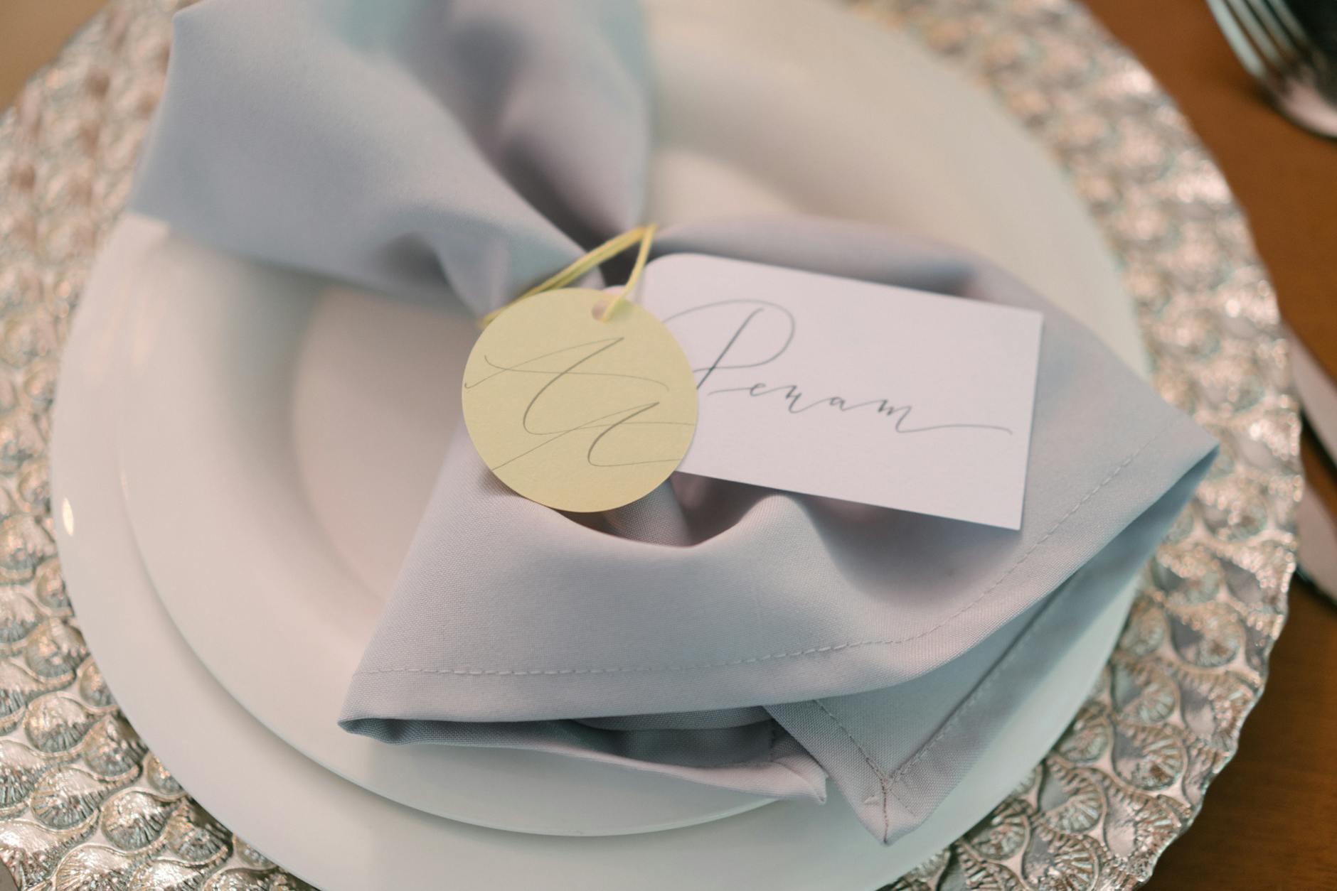 Personalized wedding favor tags showing couple names, wedding date, and floral monogram