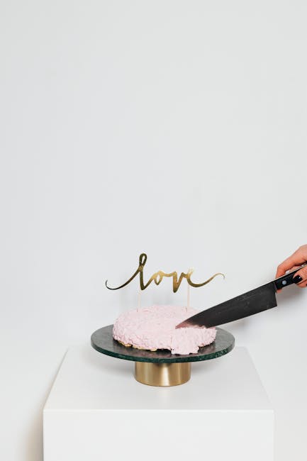 Modern minimalist gold wedding cake cutting set on a marble surface