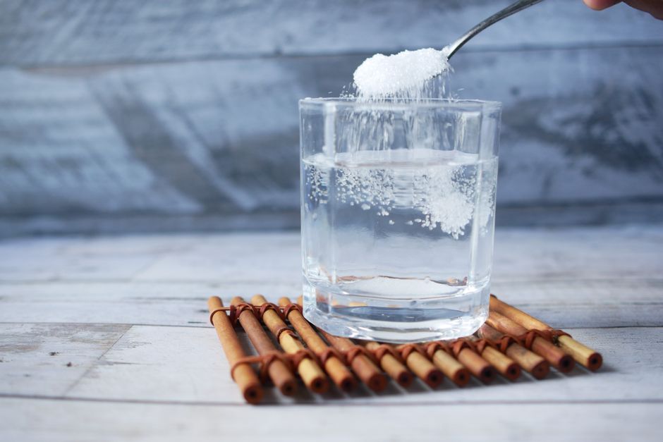 Electrolyte powder stick packets for a wedding hangover kit poured into a glass of water