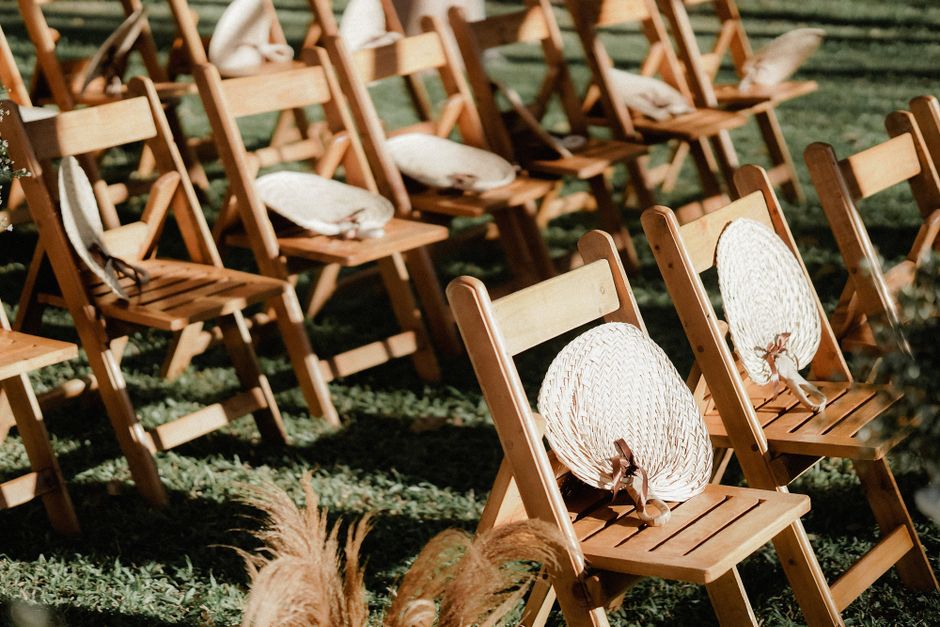 Wedding program fan ideas stacked in a basket for an outdoor ceremony