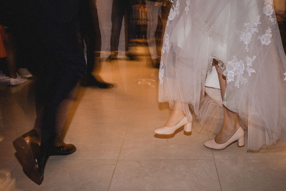 Bride wearing comfortable white sneakers while dancing at her wedding reception