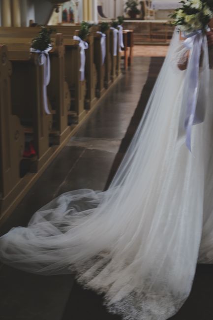 Cathedral wedding veil idea trailing behind a bride during a church processional