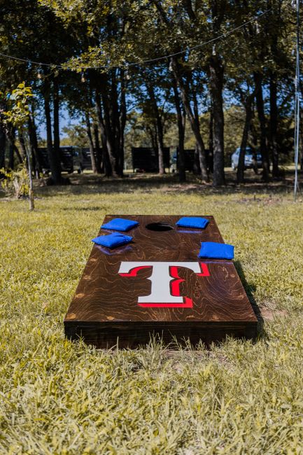 Cornhole wedding lawn game boards set up for reception guests