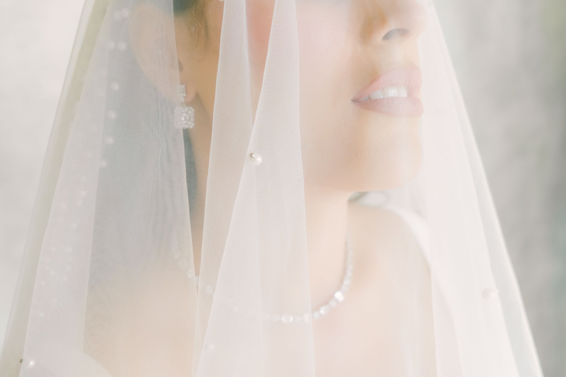 Bride wearing pearl drop earrings as part of bridal jewelry ideas for an updo hairstyle