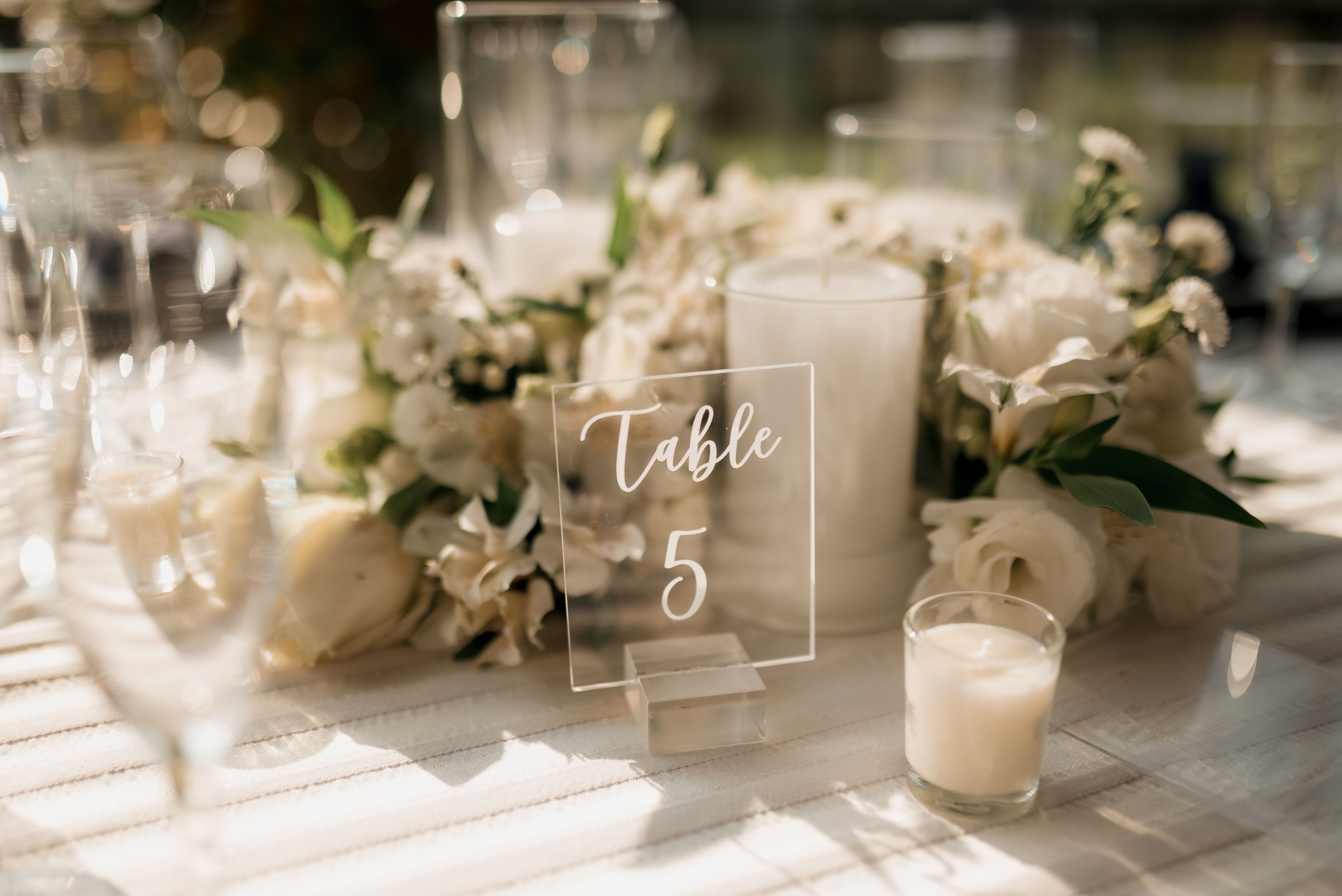 Wedding menu card displayed in a clear acrylic holder on a reception table, a practical wedding menu card display idea