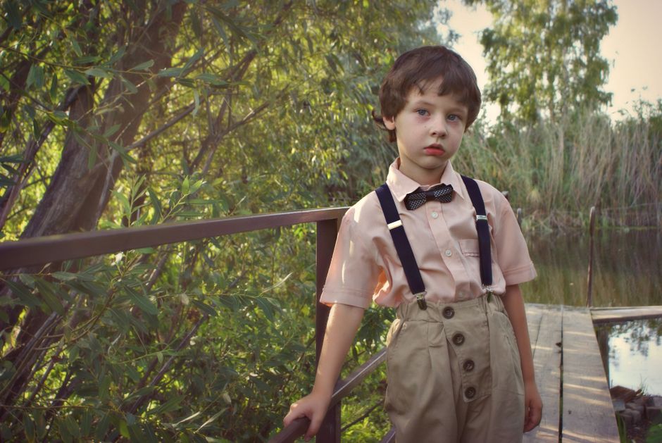 Ring bearer in suspenders and bow tie for a casual outdoor wedding