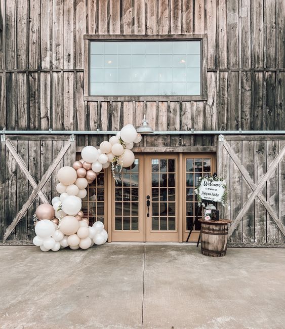 Balloon arch framing a wedding reception entrance in a neutral color palette