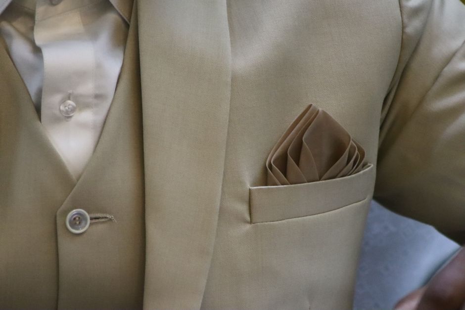 Pocket squares folded into a suit jacket pocket to complete a groomsmen tie look