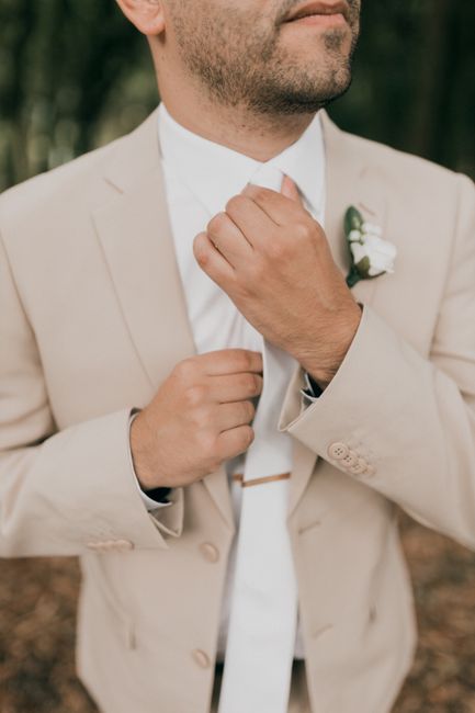 Tie clip securing a groomsman's necktie, a practical finishing touch for wedding ties