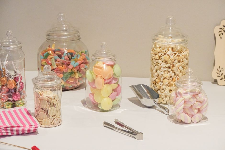 Glass apothecary jars used for wedding candy buffet ideas on a styled table