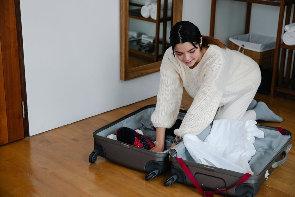 Garment bag holding a suit and dress shirt packed for wedding travel