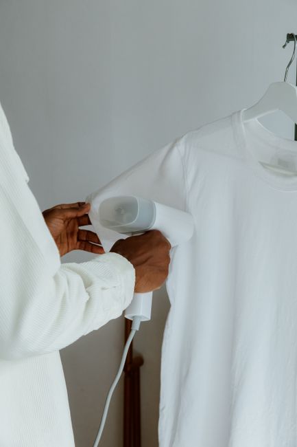 handheld wedding dress steamer working on a gown sleeve
