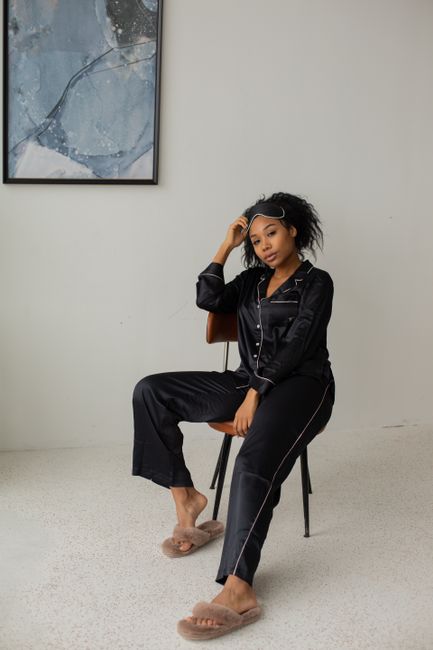 Bridesmaid pajama set with sleep mask, scrunchie, and slippers laid out as a gift