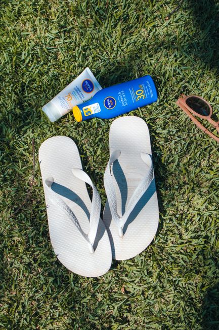 Bulk flip flops for wedding guests in assorted sizes stacked in neutral colors