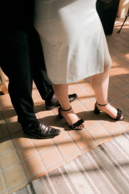 Wedding flip flops sign reading dancing shoes placed beside a guest basket