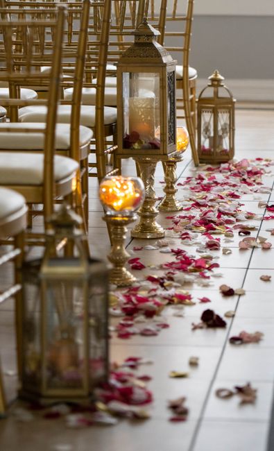 Large black floor lanterns lining a wedding aisle