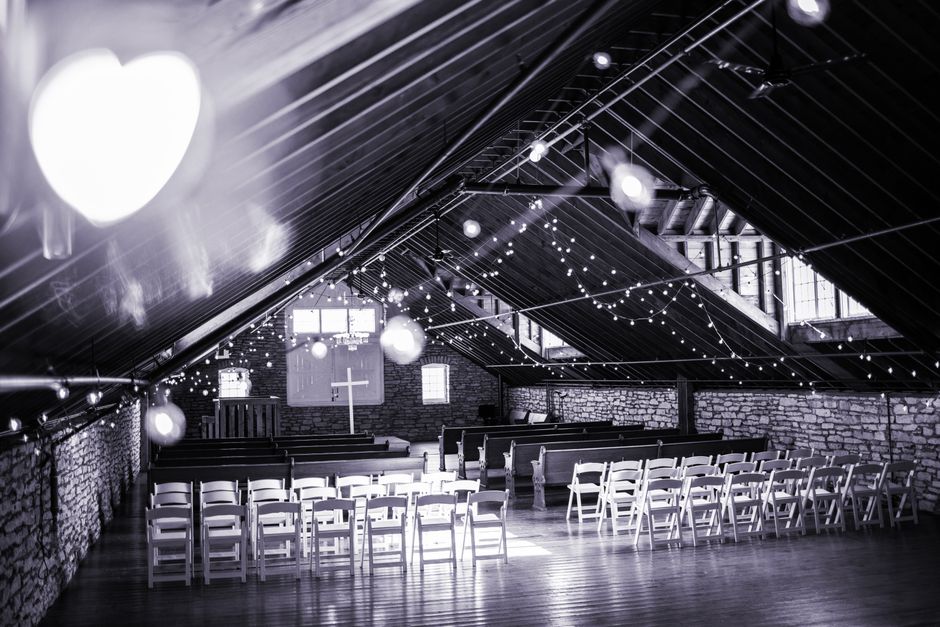 Warm white fairy lights along a church aisle for an evening wedding