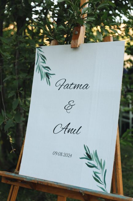 Wedding ceremony entrance with sign on easel and program table