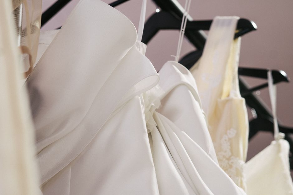 Satin robes for bridal party getting ready outfits hanging in a wedding suite