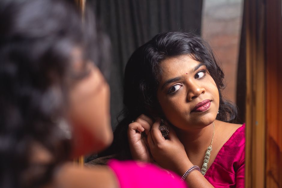 Bridesmaid putting on pearl earrings while getting ready for the wedding