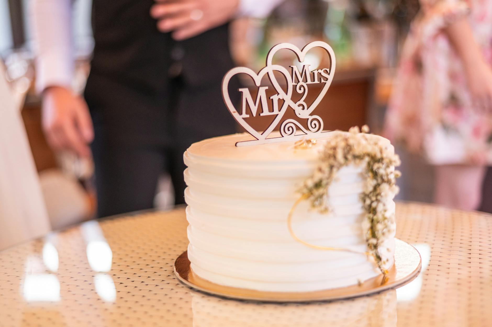 Acrylic Mr and Mrs wedding cake topper in rose gold script lettering
