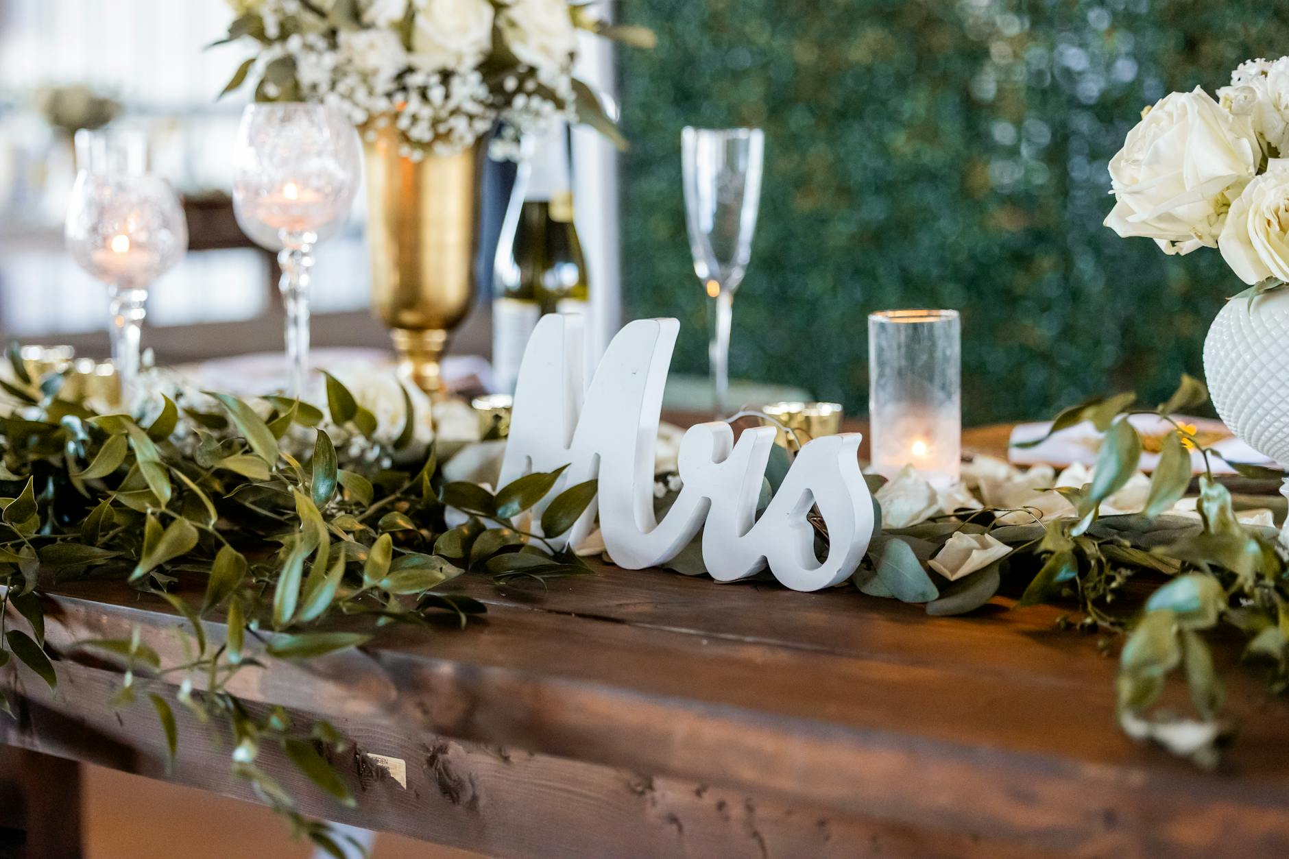 Place card display ideas at a wedding reception with greenery accents